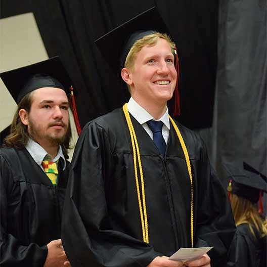 Graduating student smiling on his way to receive his diploma